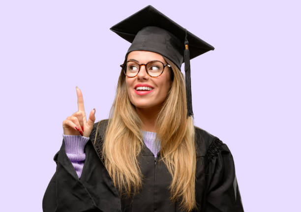 istock Young woman university graduate student happy and surprised cheering expressing wow gesture pointing up 1042425276