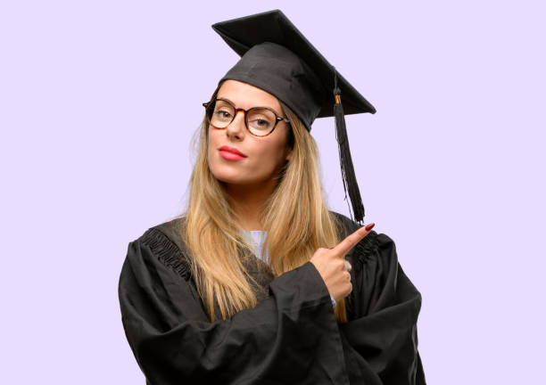 istock Young woman university graduate student pointing away side with finger 1042425398