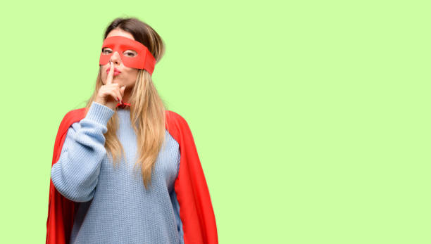 istock Young super woman with index finger on lips, ask to be quiet. Silence and secret concept 1042425502