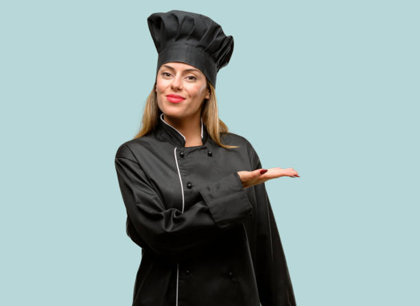 istock Young cook woman holding something in empty hand 1042425632