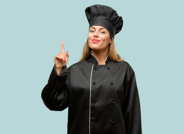 istock Young cook woman happy and surprised cheering expressing wow gesture pointing up 1042425674