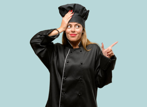 istock Young cook woman pointing away side with finger 1042425716