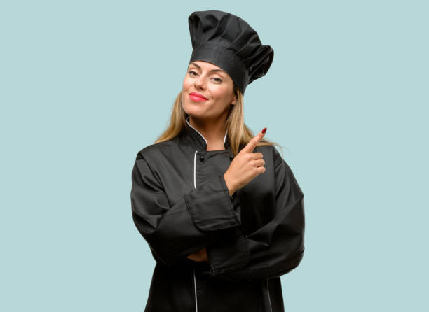 istock Young cook woman pointing away side with finger 1042425800