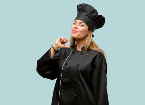 istock Young cook woman proud, excited and arrogant, pointing with victory face 1042425802
