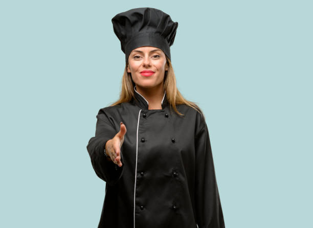istock Young cook woman holds hands welcoming in handshake pose, expressing trust and success concept, greeting 1042425892