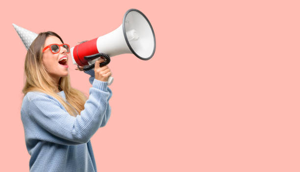 junge frau feiert geburtstag kommuniziert schreien laut hält ein megaphon, mit dem ausdruck erfolg und positives konzept, idee für marketing oder vertrieb - megaphone women at attention using voice stock-fotos und bilder