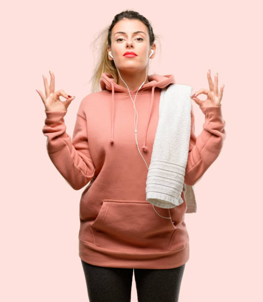 istock Young sport woman wearing workout sweatshirt doing ok sign gesture with both hands expressing meditation and relaxation 1042429054