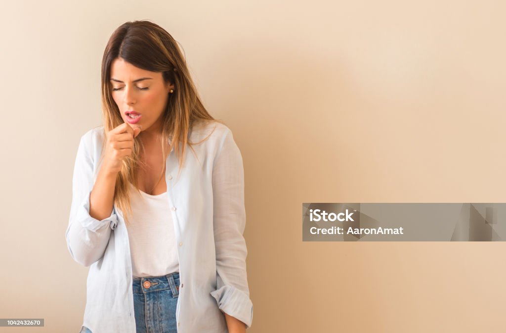 Vintage photo of a Beautiful woman against wall sick and coughing, suffering asthma or bronchitis, medicine concept Coughing Stock Photo