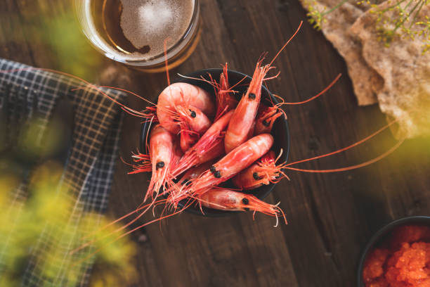 Top down view of the food and drinks at a traditional summer crayfish party in Sweden. Beautifully decorated on an old wooden table.