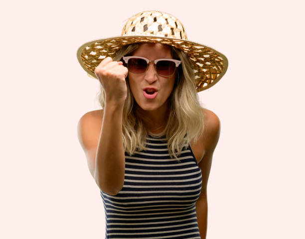 istock Young woman using sunglasses wearing summer hat irritated and angry expressing negative emotion, annoyed with someone 1042437144