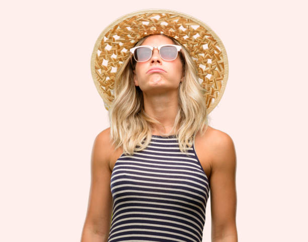 istock Young woman using sunglasses wearing summer hat with sleepy expression, being overworked and tired 1042437206
