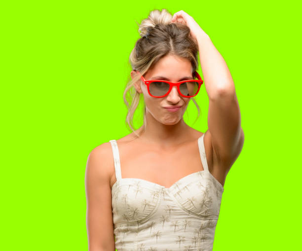 istock Young beautiful woman wearing red sunglasses doubt expression, confuse and wonder concept, uncertain future 1042437256