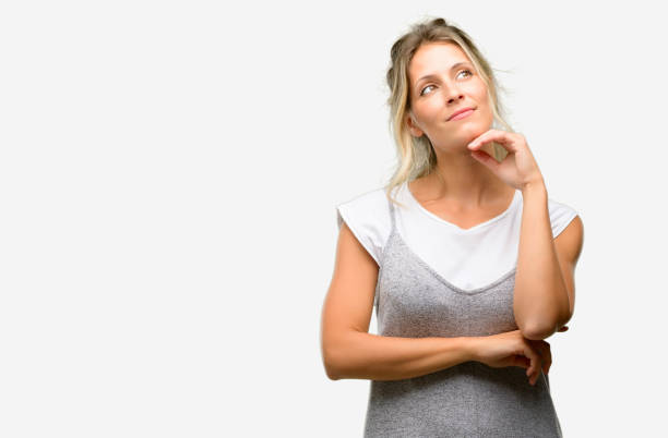Young beautiful woman thinking and looking up expressing doubt and wonder