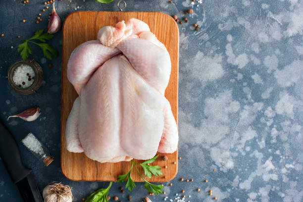 pollo crudo intero su una tavola di legno con spezie per cucinare, vista dall'alto, orizzontale, spazio di copia - raw foto e immagini stock