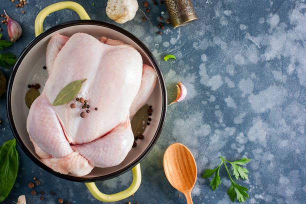 istock Prepared fresh raw chicken for cooking on a cutting wooden board, top view, selective focus 1042440342