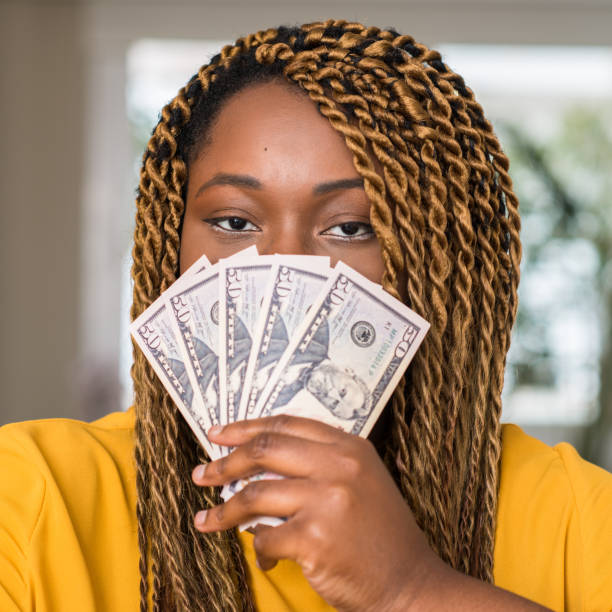 istock African american woman holding dollars with a confident expression on smart face thinking serious 1042441818