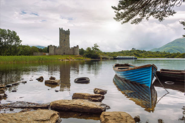 This set of images features the Church of Ireland in the heart of Donegal Town, Ireland, notable for its Gothic Revival design, pointed stone spire, and historical significance. Adjacent to the church stands Donegal Castle, a partially restored medieval structure, enhancing the historic atmosphere of the town center. The surrounding area is composed of traditional townhouses, winding roads, small local businesses, and the tranquil River Eske flowing through the landscape. Framed by lush countryside and rolling hills, this setting is emblematic of Irish heritage, offering rich storytelling for religious, historical, and architectural tourism themes.