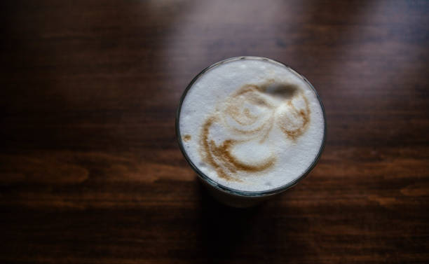 istock fragrant cappuccino on a wooden table in a glass. 1042450578