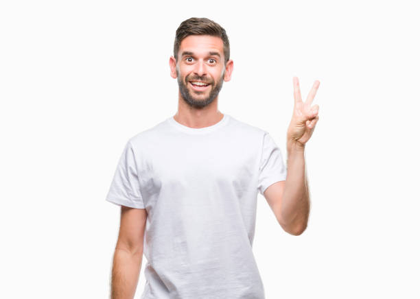 istock Young handsome man over isolated background smiling with happy face winking at the camera doing victory sign. Number two. 1042450878