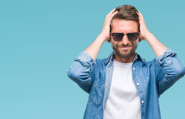 istock Young handsome man wearing sunglasses over isolated background suffering from headache desperate and stressed because pain and migraine. Hands on head. 1042450964