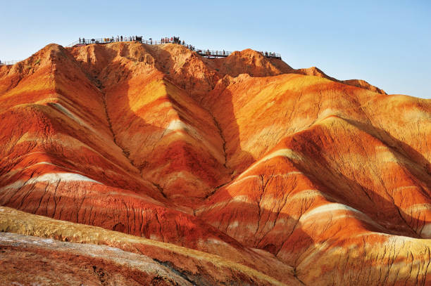 Tourists on the stand to see the beautiful scenery of Danxia landform  in the National Geopark of Zhangye, Gansu, China. Tourists on the stand to see the beautiful scenery of Danxia landform  in the National Geopark of Zhangye, Gansu, China. danxia landform stock pictures, royalty-free photos & images