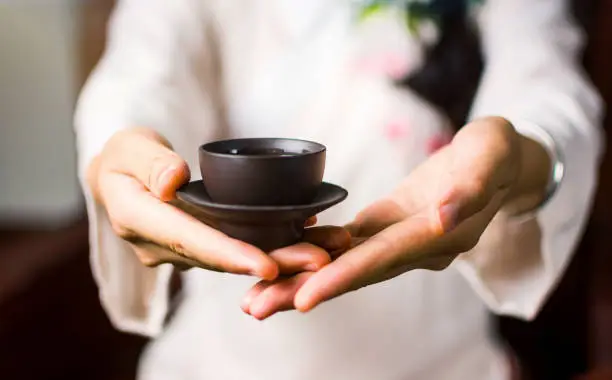 Woman serving Chinese tea in a traditional tea ceremony