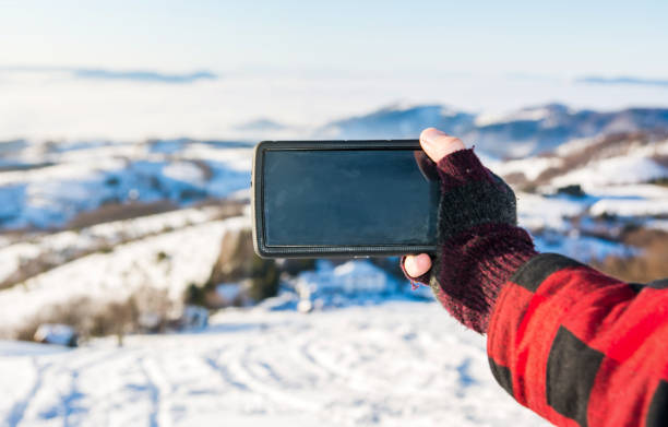 istock Man taking picture with a smart phone in the winter 1042454140