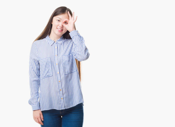 istock Young Chinese woman over isolated background doing ok gesture with hand smiling, eye looking through fingers with happy face. 1042457430