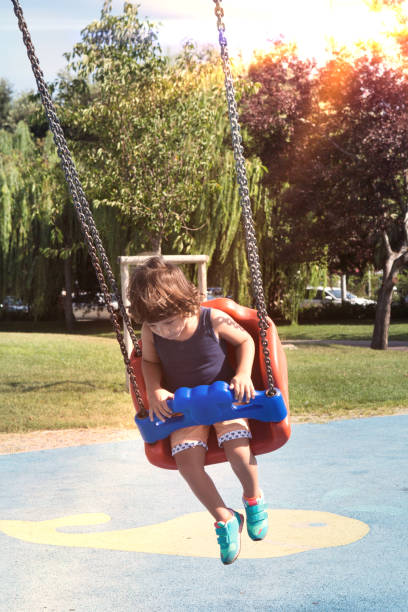 istock Happy laughing baby boy in swing on playground 1042458076