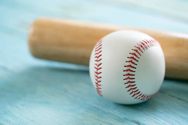 istock baseball and baseball bat on wooden table background, close up 1042461148