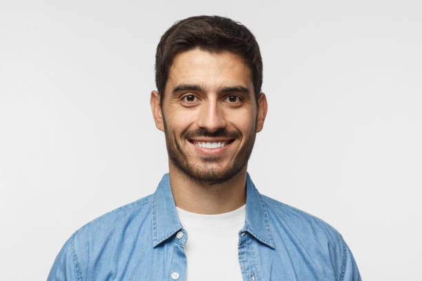 istock Smiling handsome man in blue shirt isolated on gray background 1042466548
