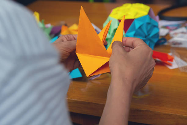 istock Hands of a man creating a colored origami paper. Creativity 1042466656