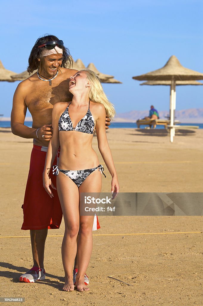 Couple souriant sur la plage - Photo de Adolescent libre de droits