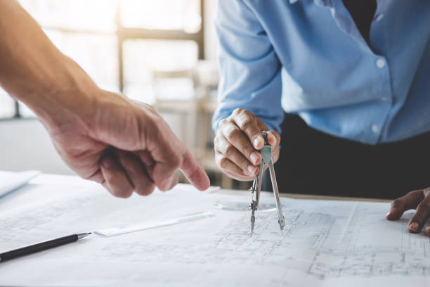 istock Hands of architect or engineer working on blueprint meeting for project working with partner on model building and engineering tools in working site, Construction concept 1042471246
