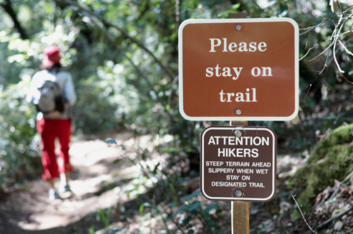 Please stay on trail sign next to path in Rocky Mountains