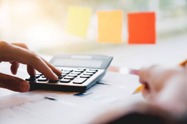 istock Close up woman using calculator and writing make note with calculate about cost at home office. 1042499012