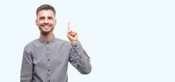 istock Young hipster man showing and pointing up with finger number one while smiling confident and happy. 1042510074