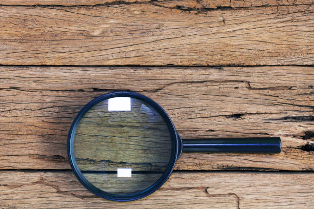 istock magnifying glass on old wooden table background. 1042514718