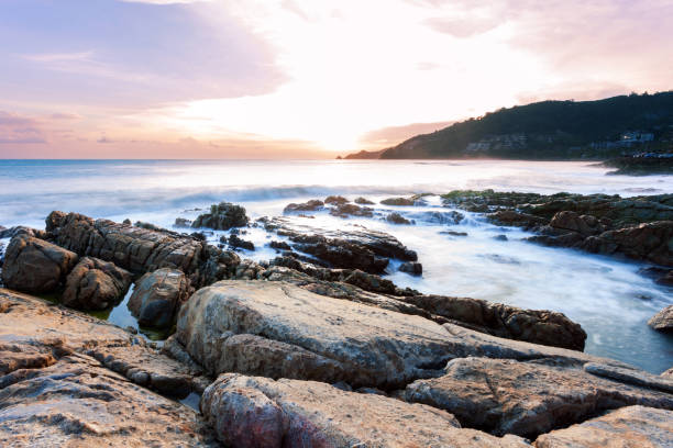 istock Long exposure image of Dramatic sky seascape with rock in sunset scenery background. 1042514778