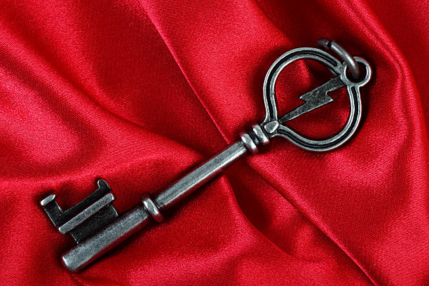 istock Old vintage key in red satin cloth background 104251995