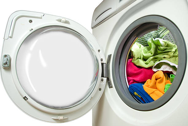 Close up of washing machine with door ajar, laundry inside stock photo