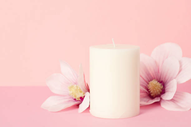 istock Delicate flower scented candle over pastel pink background with copy space 1042523896