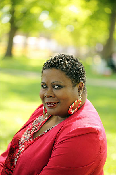 Portrait of a smiling woman wearing jewelry, enjoying a carefree moment by the ocean during a seaside vacation at dusk.