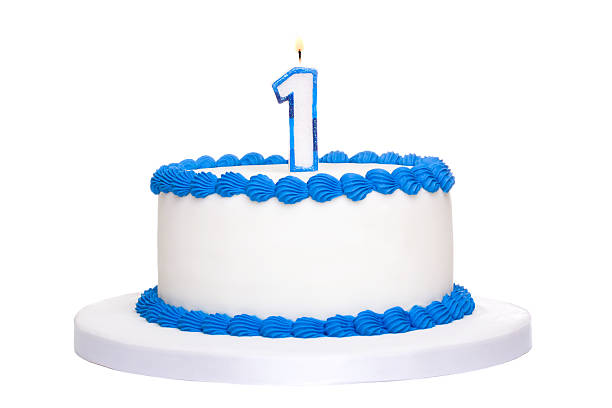 istock White birthday cake with blue piping with a 1 candle on top 104253130