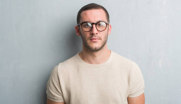 istock Young caucasian man over grey grunge wall with a confident expression on smart face thinking serious 1042534594