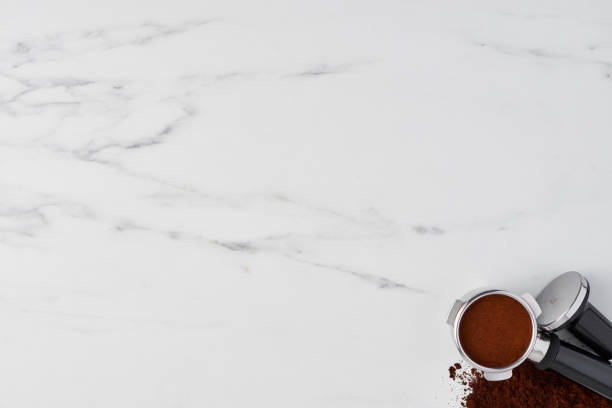 istock Coffee tamper and portafilter with gorund coffee on white marble 1042535850