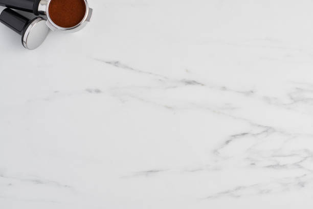 istock Coffee tamper and portafilter with gorund coffee on white marble 1042535918