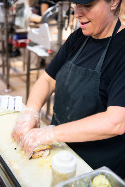 istock A employee in a deli making a sandwich to order 1042538738