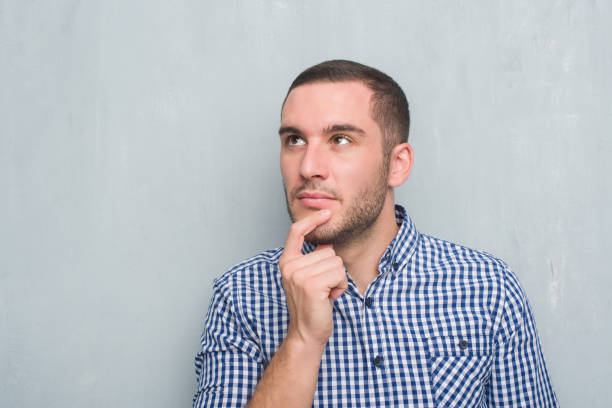 istock Young caucasian man over grey grunge wall serious face thinking about question, very confused idea 1042539778