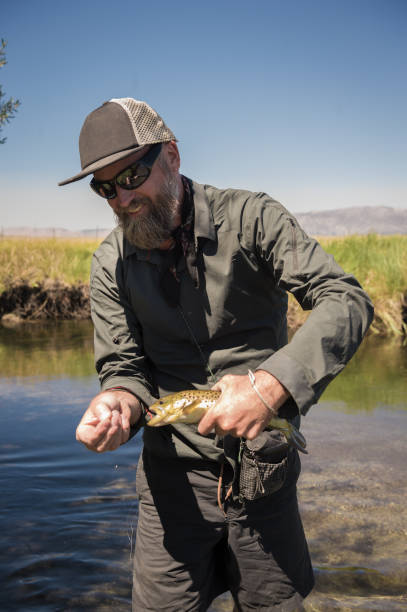 istock Fly Fisherman Showing Off His Catch 1042557726